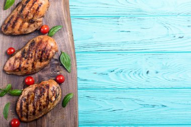 Izgara tavuk göğsü (fileto) fesleğen ve domates ile. Barbekü arka plan