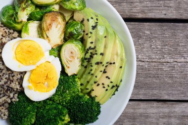 Quinoa, yumurta, avokado, Brüksel lahanası ve brokoli ile Buda kase. Ahşap backggroun yiyecek vegan salataya