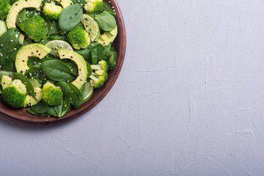Yeşil bebek ıspanak salatası avokado, brokoli, salatalık, kireç ve susam. Sağlıklı detoks vegan gıda