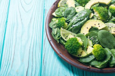 Yeşil bebek ıspanak salatası avokado, brokoli, salatalık, kireç ve susam. Sağlıklı detoks vegan gıda