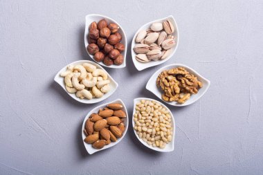 Fındık karışımı: antep fıstığı, badem, ceviz, çam fıstığı, fındık ve kaju. Kase backgrond içinde snack