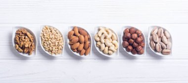 Fındık karışımı: antep fıstığı, badem, ceviz, çam fıstığı, fındık ve kaju. Kase backgrond içinde snack