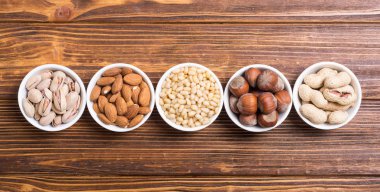 Fındık karışımı: antep fıstığı, badem, ceviz, çam fıstığı, fındık ve kaju. Kase backgrond içinde snack