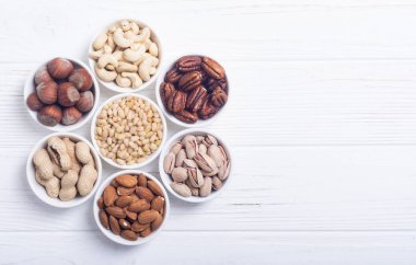 Fındık karışımı: antep fıstığı, badem, ceviz, çam fıstığı, fındık ve kaju. Kase backgrond içinde snack