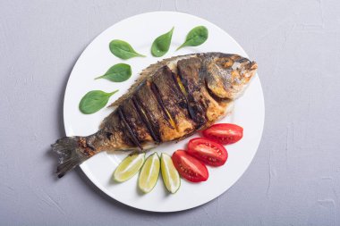 Kızarmış balık dorado limon, domates ve ıspanak ile. Deniz gıda arka plan