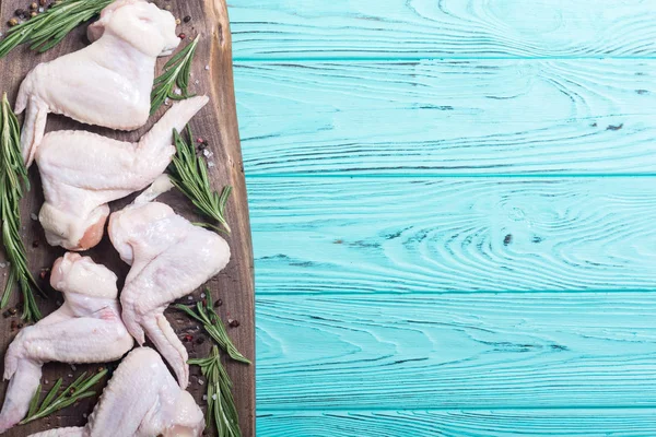 Chicken raw wings with rosemary , garlic , pepper and salt . Ingredient for preparation