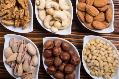 Fındık karışımı: antep fıstığı, badem, ceviz, çam fıstığı, fındık ve kaju. Kase backgrond içinde snack