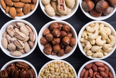 Fındık karışımı: antep fıstığı, badem, ceviz, çam fıstığı, fındık ve kaju. Kase backgrond içinde snack