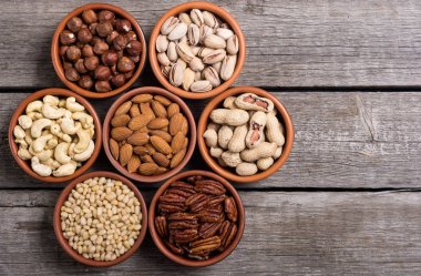 Fındık karışımı: antep fıstığı, badem, ceviz, çam fıstığı, fındık ve kaju. Kase backgrond içinde snack