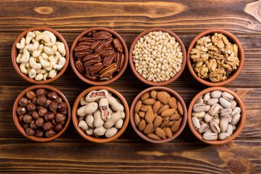 Fındık karışımı: antep fıstığı, badem, ceviz, çam fıstığı, fındık ve kaju. Kase backgrond içinde snack