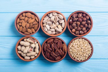 Fındık karışımı: antep fıstığı, badem, ceviz, çam fıstığı, fındık ve kaju. Kase backgrond içinde snack