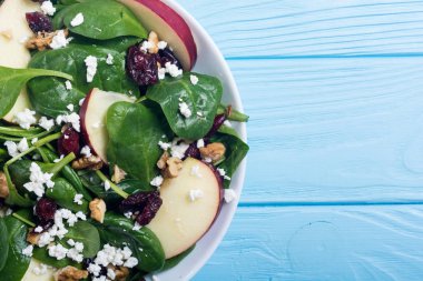 Elma, peynir, ceviz ve kurutulmuş kızılcık sonbahar ıspanak salatası. Sağlıklı vejetaryen yemek