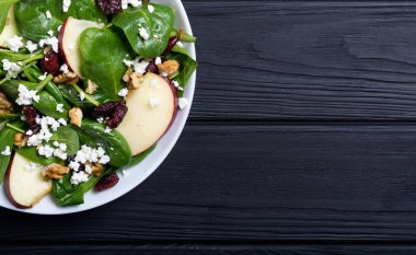 Elma, peynir, ceviz ve kurutulmuş kızılcık sonbahar ıspanak salatası. Sağlıklı vejetaryen yemek