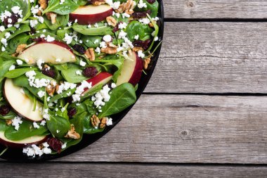 Elma, peynir, ceviz ve kurutulmuş kızılcık sonbahar ıspanak salatası. Sağlıklı vejetaryen yemek