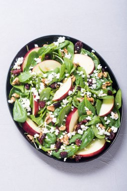 Elma, peynir, ceviz ve kurutulmuş kızılcık sonbahar ıspanak salatası. Sağlıklı vejetaryen yemek