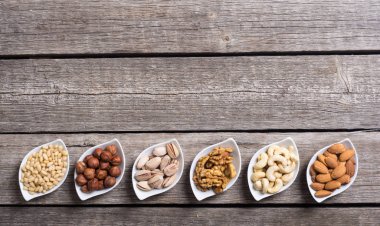 Fındık karışımı: antep fıstığı, badem, ceviz, çam fıstığı, fındık ve kaju. Kase backgrond içinde snack