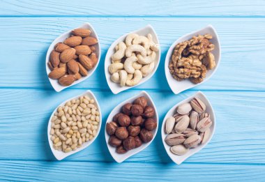 Fındık karışımı: antep fıstığı, badem, ceviz, çam fıstığı, fındık ve kaju. Kase backgrond içinde snack