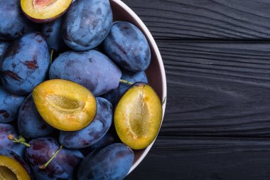 Ahşap masa üzerinde kase taze erik. Meyve arka plan