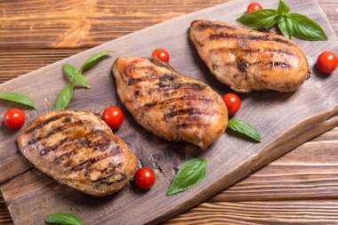 Izgara tavuk göğsü (fileto) fesleğen ve domates ile. Barbekü arka plan