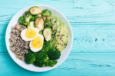 Quinoa, yumurta, avokado, Brüksel lahanası ve brokoli ile Buda kase. Ahşap backggroun yiyecek vegan salataya