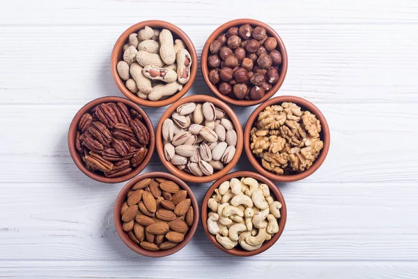 Fındık karışımı: antep fıstığı, badem, ceviz, çam fıstığı, fındık ve kaju. Kase backgrond içinde snack