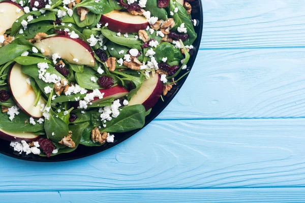 Elma, peynir, ceviz ve kurutulmuş kızılcık sonbahar ıspanak salatası. Sağlıklı vejetaryen yemek