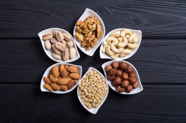 Fındık karışımı: antep fıstığı, badem, ceviz, çam fıstığı, fındık ve kaju. Kase backgrond içinde snack
