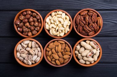 Fındık karışımı: antep fıstığı, badem, ceviz, çam fıstığı, fındık ve kaju. Kase backgrond içinde snack