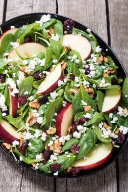 Elma, peynir, ceviz ve kurutulmuş kızılcık sonbahar ıspanak salatası. Sağlıklı vejetaryen yemek