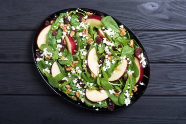 Elma, peynir, ceviz ve kurutulmuş kızılcık sonbahar ıspanak salatası. Sağlıklı vejetaryen yemek