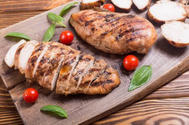 Izgara tavuk göğsü (fileto) fesleğen ve domates ile. Barbekü arka plan