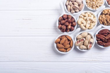 Fındık karışımı: antep fıstığı, badem, ceviz, çam fıstığı, fındık ve kaju. Kase backgrond içinde snack