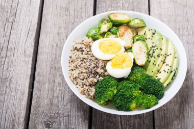 Quinoa, yumurta, avokado, Brüksel lahanası ve brokoli ile Buda kase. Ahşap backggroun yiyecek vegan salataya