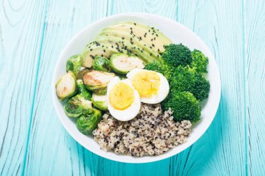 Quinoa, yumurta, avokado, Brüksel lahanası ve brokoli ile Buda kase. Ahşap backggroun yiyecek vegan salataya