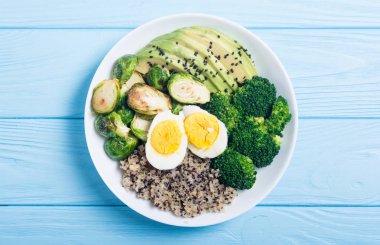 Quinoa, yumurta, avokado, Brüksel lahanası ve brokoli ile Buda kase. Ahşap backggroun yiyecek vegan salataya