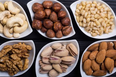 Fındık karışımı: antep fıstığı, badem, ceviz, çam fıstığı, fındık ve kaju. Kase backgrond içinde snack