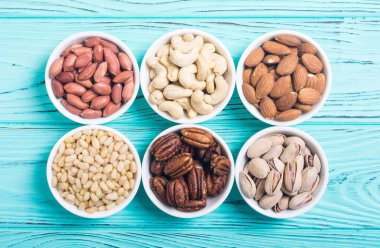 Fındık karışımı: antep fıstığı, badem, ceviz, çam fıstığı, fındık ve kaju. Kase backgrond içinde snack