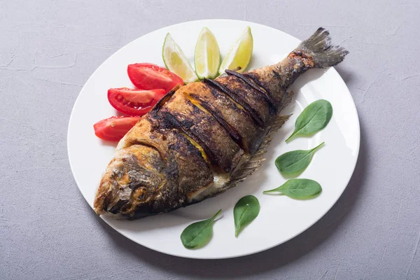 Kızarmış balık dorado limon, domates ve ıspanak ile. Deniz gıda arka plan