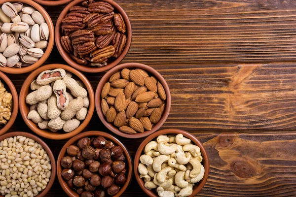 Fındık karışımı: antep fıstığı, badem, ceviz, çam fıstığı, fındık ve kaju. Kase backgrond içinde snack