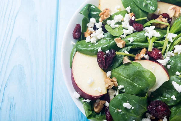 Elma, peynir, ceviz ve kurutulmuş kızılcık sonbahar ıspanak salatası. Sağlıklı vejetaryen yemek