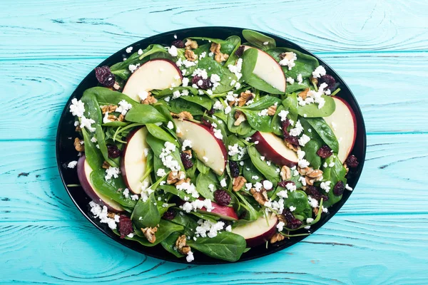 Autumn spinach salad with apple , cheese , walnut and dried cranberry . Healthy vegetarian food