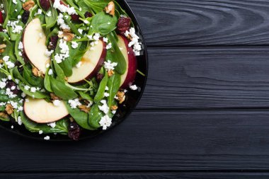 Elma, peynir, ceviz ve kurutulmuş kızılcık sonbahar ıspanak salatası. Sağlıklı vejetaryen yemek