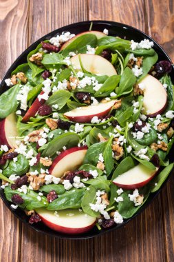 Elma, peynir, ceviz ve kurutulmuş kızılcık sonbahar ıspanak salatası. Sağlıklı vejetaryen yemek
