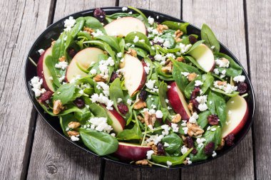 Elma, peynir, ceviz ve kurutulmuş kızılcık sonbahar ıspanak salatası. Sağlıklı vejetaryen yemek