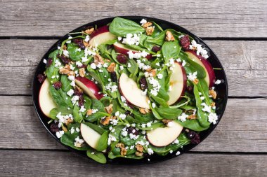 Elma, peynir, ceviz ve kurutulmuş kızılcık sonbahar ıspanak salatası. Sağlıklı vejetaryen yemek
