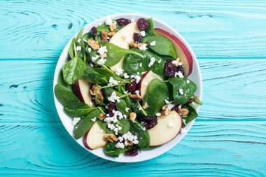 Elma, peynir, ceviz ve kurutulmuş kızılcık sonbahar ıspanak salatası. Sağlıklı vejetaryen yemek