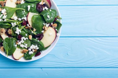 Elma, peynir, ceviz ve kurutulmuş kızılcık sonbahar ıspanak salatası. Sağlıklı vejetaryen yemek