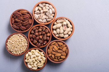 Fındık karışımı: antep fıstığı, badem, ceviz, çam fıstığı, fındık ve kaju. Kase backgrond içinde snack