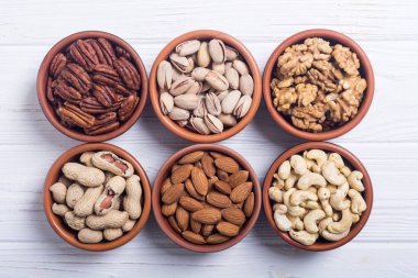 Fındık karışımı: antep fıstığı, badem, ceviz, çam fıstığı, fındık ve kaju. Kase backgrond içinde snack