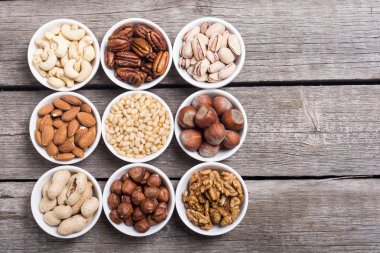 Fındık karışımı: antep fıstığı, badem, ceviz, çam fıstığı, fındık ve kaju. Kase backgrond içinde snack